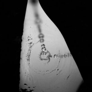 Home Black and white top view of clear puddle with droplets of water on dark street with shadow in evening time